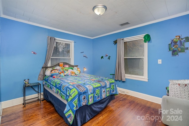 bedroom with crown molding and dark wood-type flooring