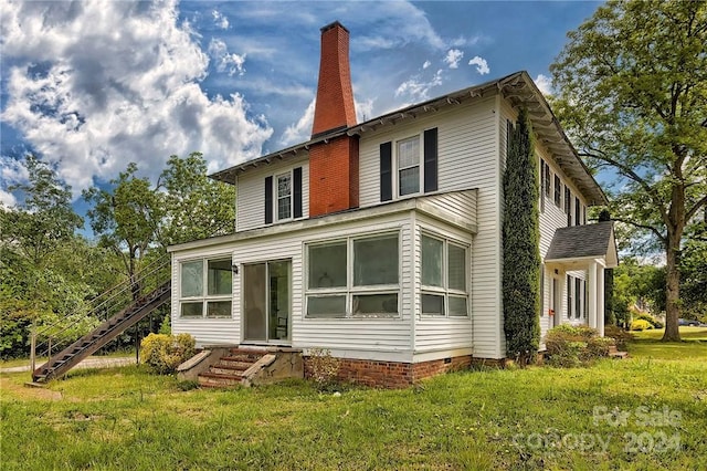 rear view of house featuring a lawn