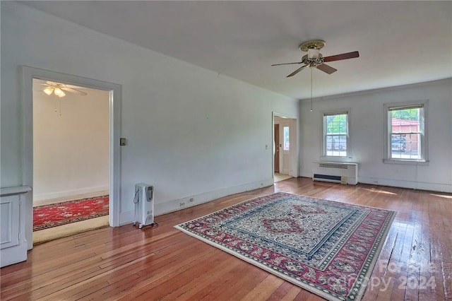 unfurnished living room with ceiling fan, crown molding, light wood-type flooring, and radiator heating unit