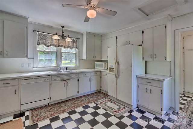 kitchen with white appliances, white cabinets, sink, hanging light fixtures, and ceiling fan