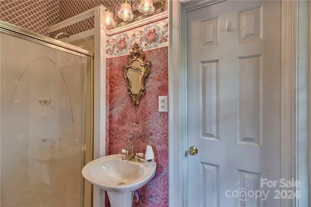 bathroom featuring an enclosed shower and sink