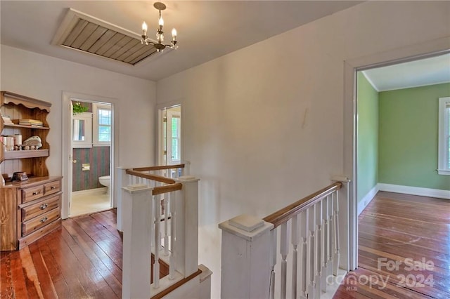 hallway with a chandelier and dark hardwood / wood-style floors