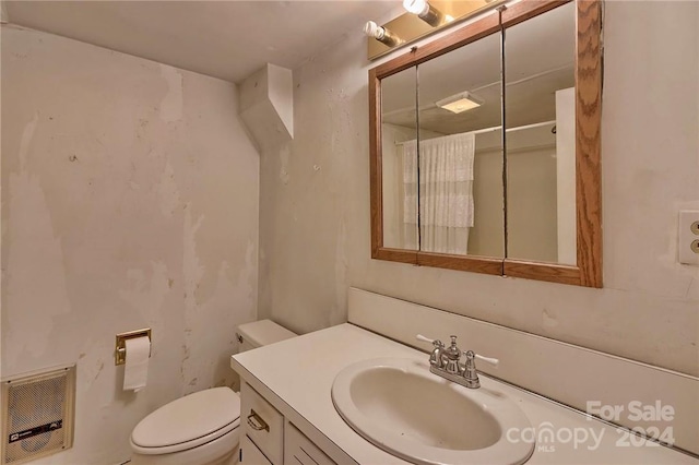 bathroom featuring a shower, vanity, heating unit, and toilet