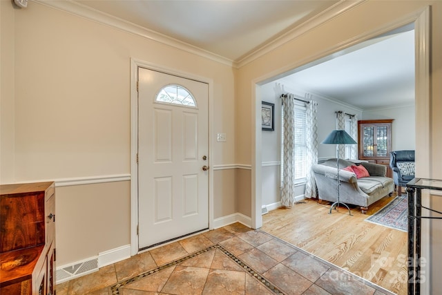 entryway with tile patterned floors, a wealth of natural light, and crown molding