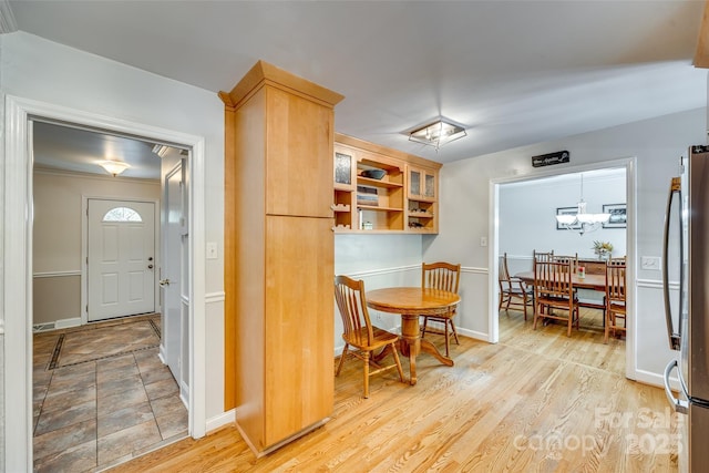 kitchen featuring stainless steel fridge, light brown cabinets, pendant lighting, and light hardwood / wood-style flooring