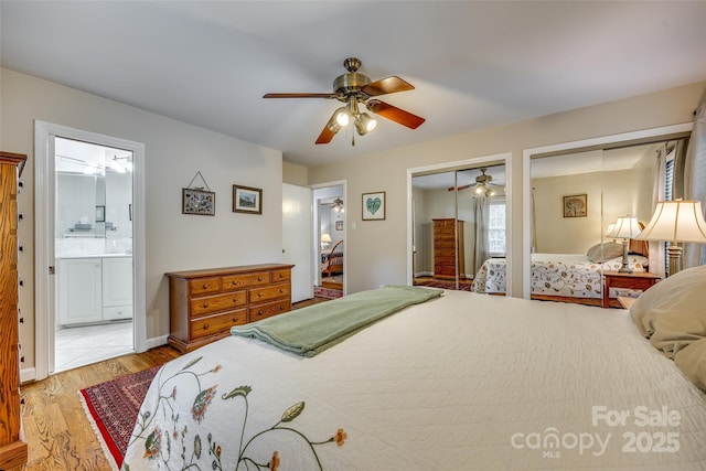 bedroom with light wood-type flooring, two closets, ceiling fan, and connected bathroom