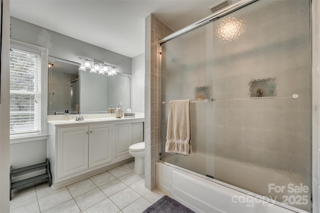 full bathroom with toilet, tile patterned floors, a wealth of natural light, and enclosed tub / shower combo