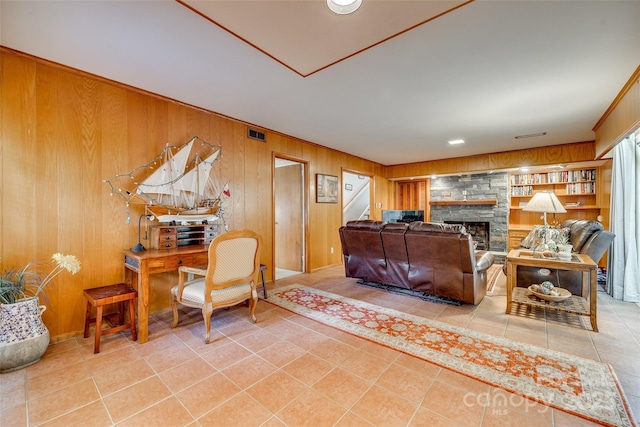 tiled living room featuring built in features, a fireplace, and wooden walls