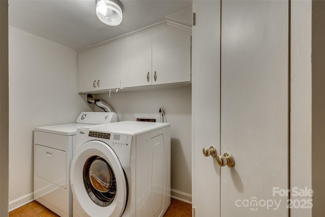 washroom featuring cabinets, light tile patterned flooring, and washing machine and clothes dryer