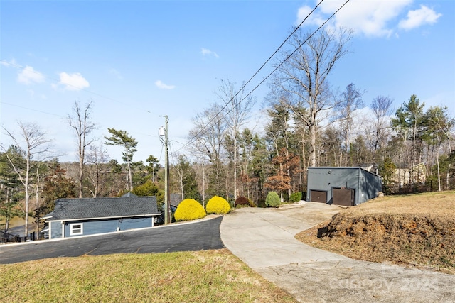 view of yard with a garage and an outbuilding