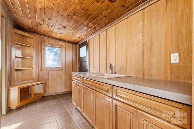 interior space with tile patterned flooring, wood ceiling, sink, and wooden walls