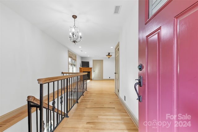 corridor featuring light hardwood / wood-style floors and a notable chandelier