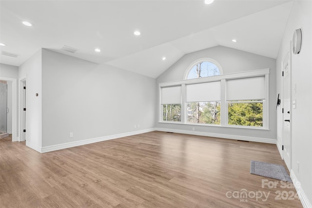 unfurnished living room featuring vaulted ceiling and light wood-type flooring