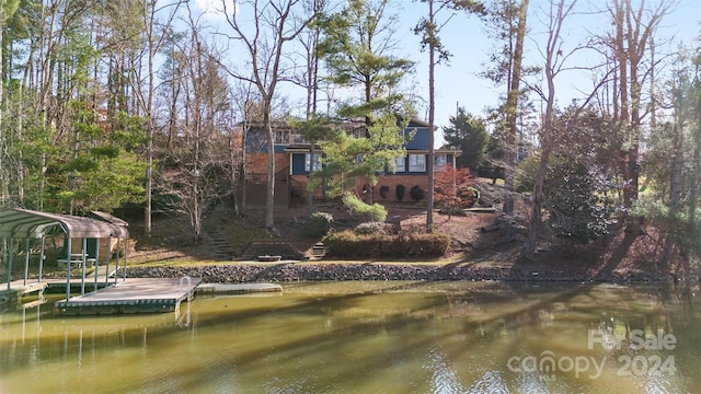 back of property featuring a carport and a water view