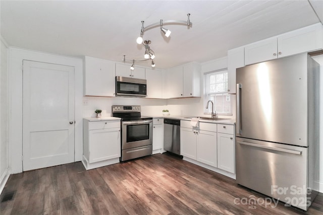 kitchen featuring stainless steel appliances, white cabinetry, sink, and dark wood-type flooring