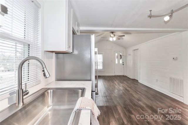 kitchen featuring lofted ceiling, sink, white cabinets, and plenty of natural light