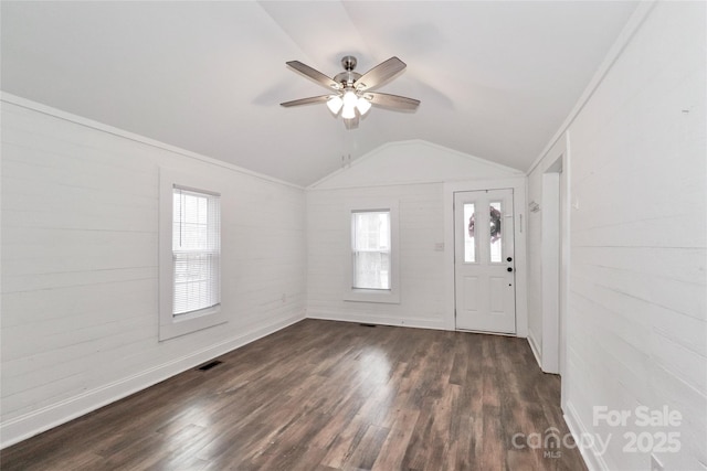 entrance foyer featuring ornamental molding, lofted ceiling, plenty of natural light, and dark hardwood / wood-style flooring