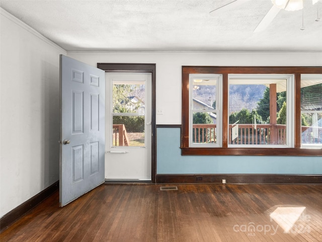 interior space with a textured ceiling, dark hardwood / wood-style floors, ceiling fan, and crown molding