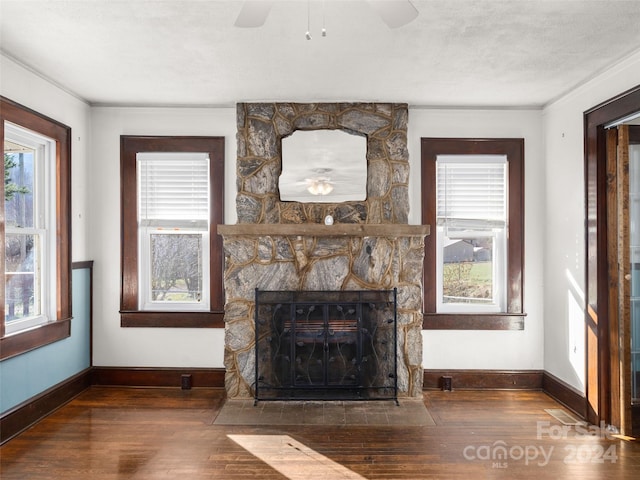 unfurnished living room with a fireplace, a textured ceiling, dark hardwood / wood-style floors, and ornamental molding