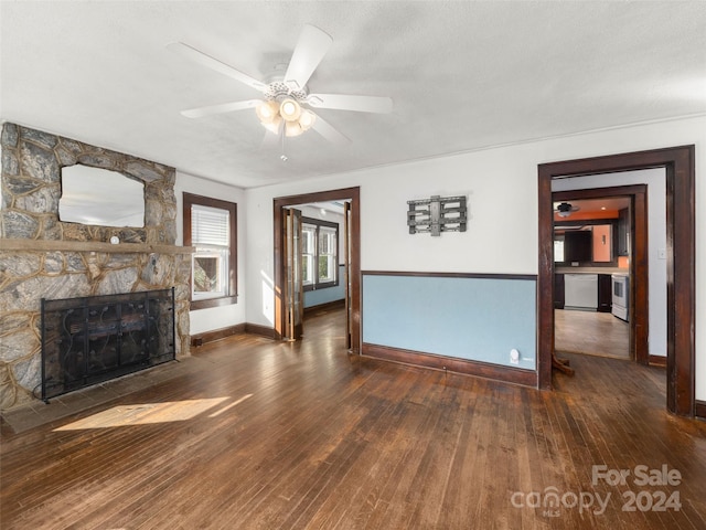 unfurnished living room with a fireplace, a textured ceiling, dark hardwood / wood-style floors, and ceiling fan