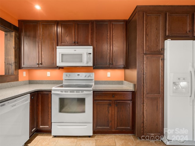 kitchen with light tile patterned floors and white appliances