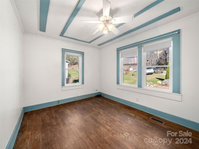 empty room featuring dark hardwood / wood-style floors, a healthy amount of sunlight, crown molding, and ceiling fan