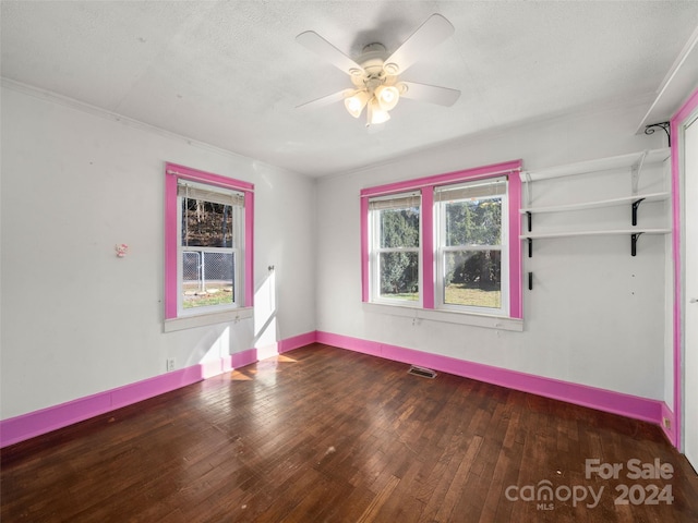 spare room with dark hardwood / wood-style floors, plenty of natural light, ornamental molding, and ceiling fan