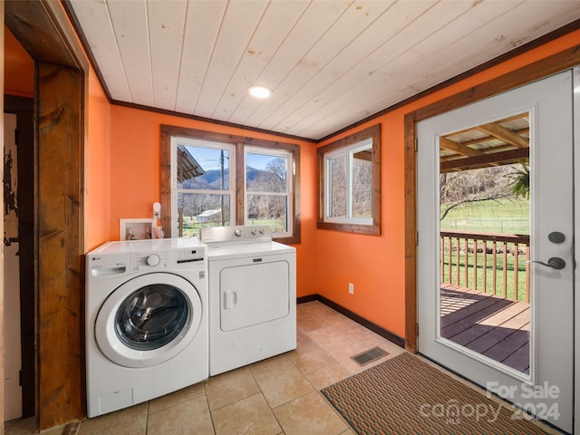 laundry room featuring light tile patterned flooring, wood ceiling, and washing machine and clothes dryer