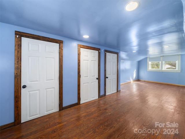 interior space with wood-type flooring and vaulted ceiling