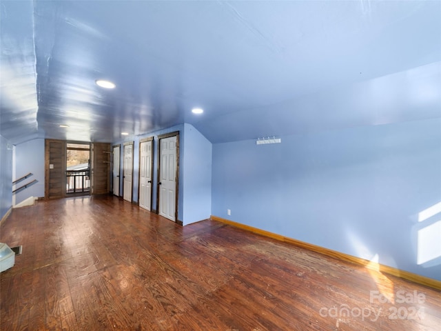 bonus room with dark hardwood / wood-style floors and vaulted ceiling