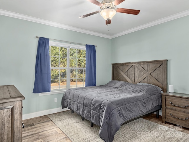 bedroom featuring ceiling fan, crown molding, and light hardwood / wood-style flooring