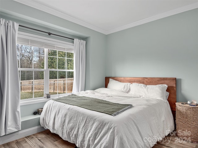 bedroom with hardwood / wood-style flooring and ornamental molding