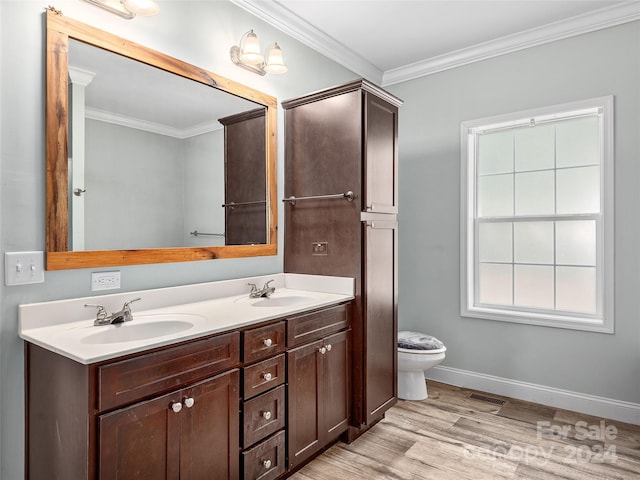 bathroom with wood-type flooring, vanity, toilet, and crown molding