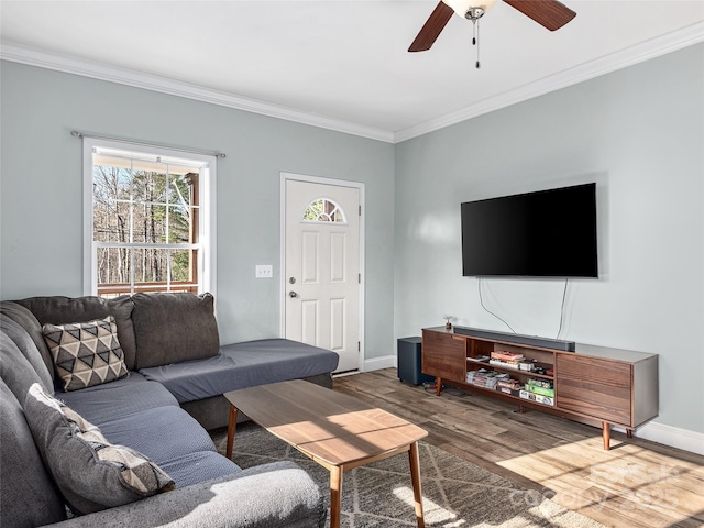 living room featuring ornamental molding, wood finished floors, a ceiling fan, and baseboards