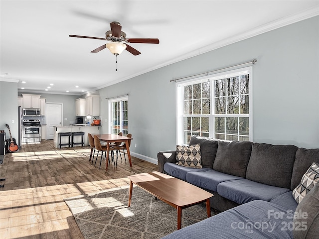 living room with baseboards, recessed lighting, wood finished floors, and crown molding