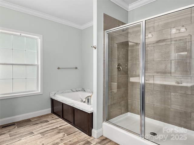 full bath featuring ornamental molding, a shower stall, wood finished floors, baseboards, and a bath