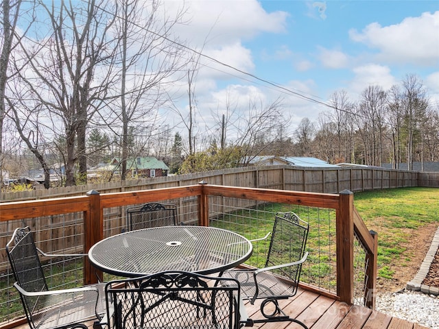 wooden deck with outdoor dining area, a fenced backyard, and a yard