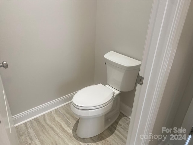 bathroom with wood-type flooring and toilet