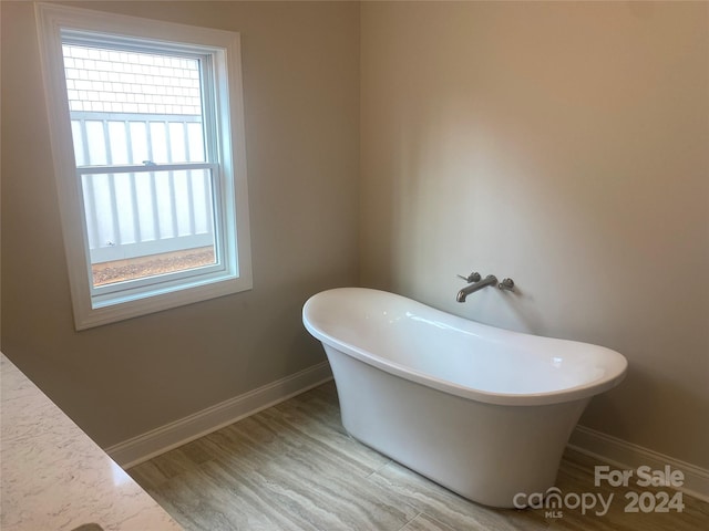 bathroom with wood-type flooring and a tub