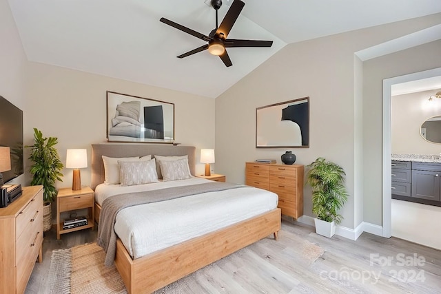 bedroom with light hardwood / wood-style floors, ensuite bath, ceiling fan, and lofted ceiling