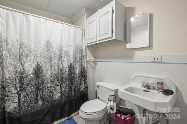 bathroom with sink, curtained shower, toilet, and tile walls