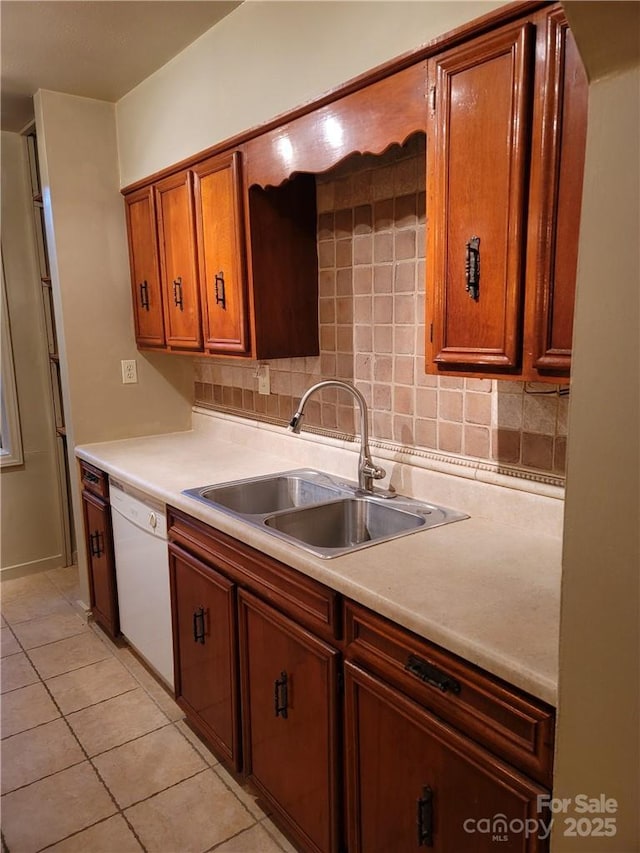 kitchen featuring dishwasher, light tile patterned flooring, decorative backsplash, and sink