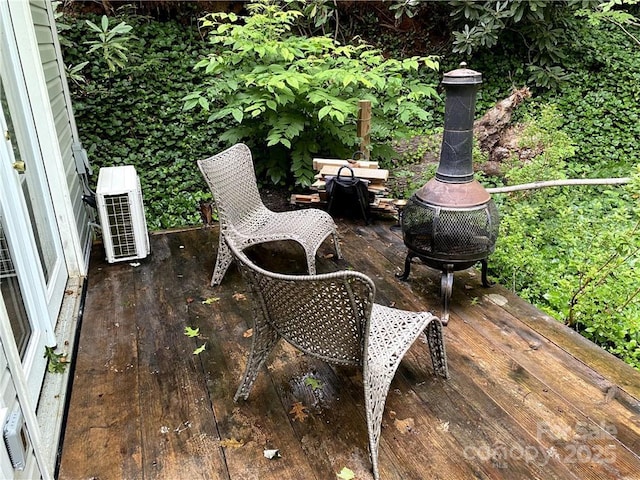 wooden terrace with ac unit and a fire pit