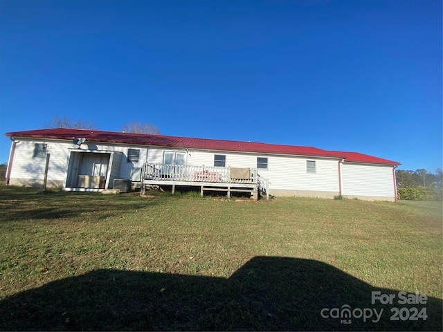 back of house featuring a yard and a wooden deck