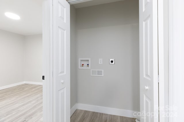 washroom featuring hookup for a washing machine, light hardwood / wood-style flooring, and hookup for an electric dryer