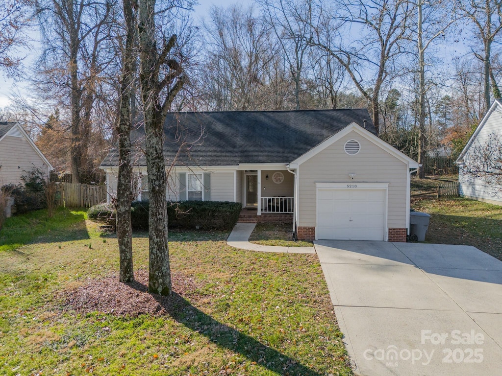 single story home with a garage, covered porch, and a front lawn