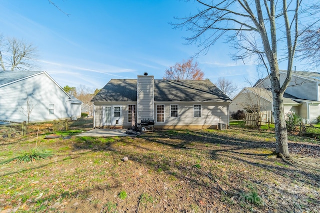 rear view of house featuring a lawn and a patio area