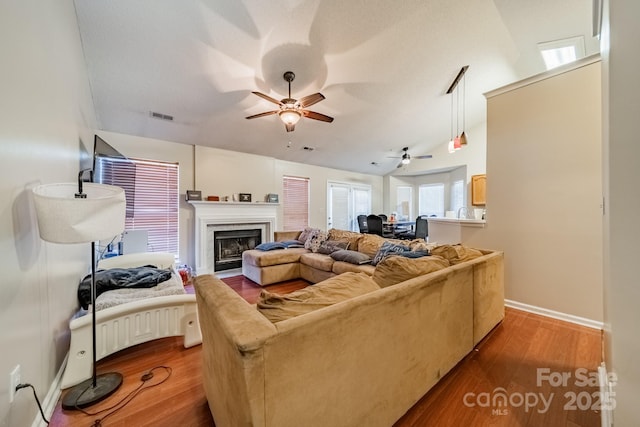 living room with hardwood / wood-style flooring, lofted ceiling, and ceiling fan