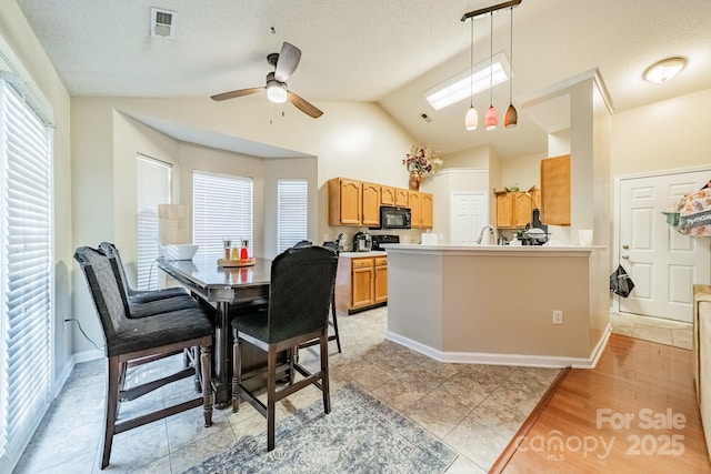 dining area with ceiling fan, vaulted ceiling, light hardwood / wood-style floors, and a textured ceiling