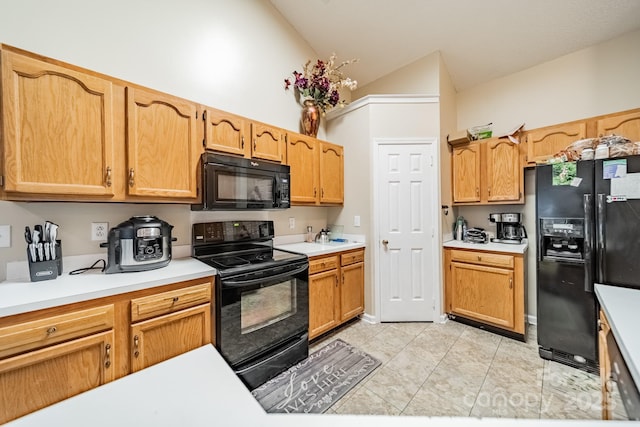 kitchen with light tile patterned flooring, lofted ceiling, and black appliances